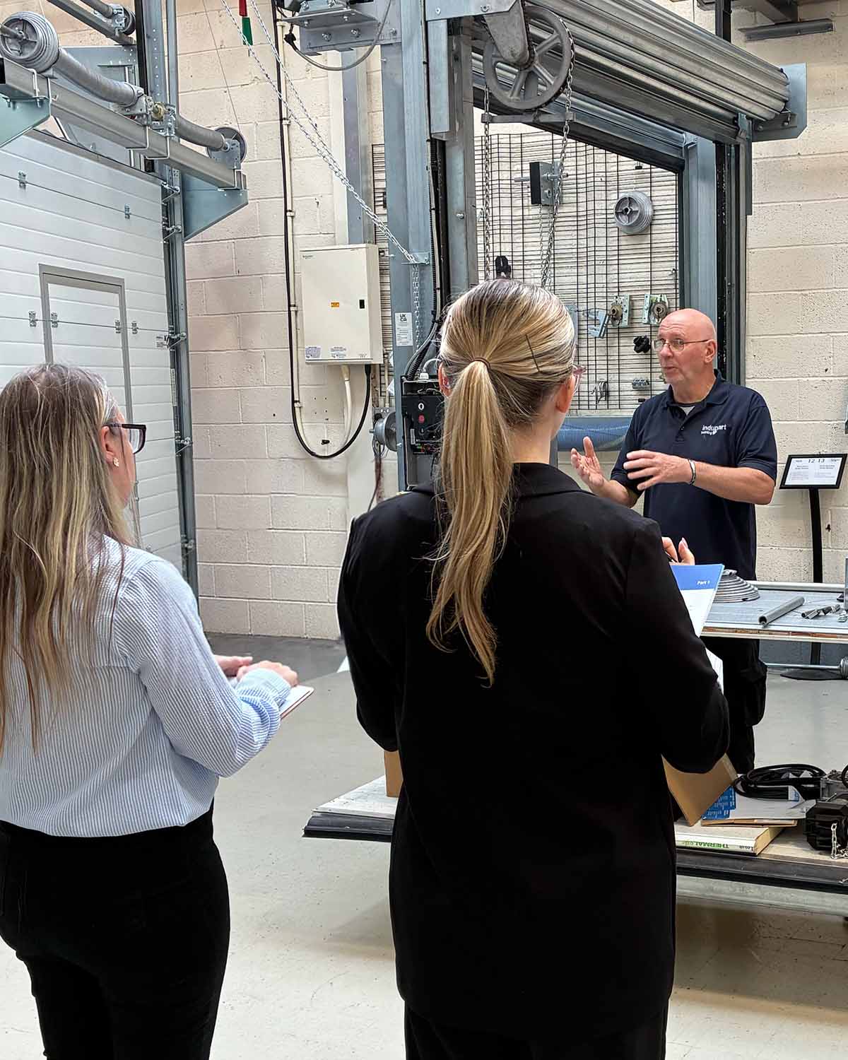 Office-based colleagues attending an industrial door awareness demonstration